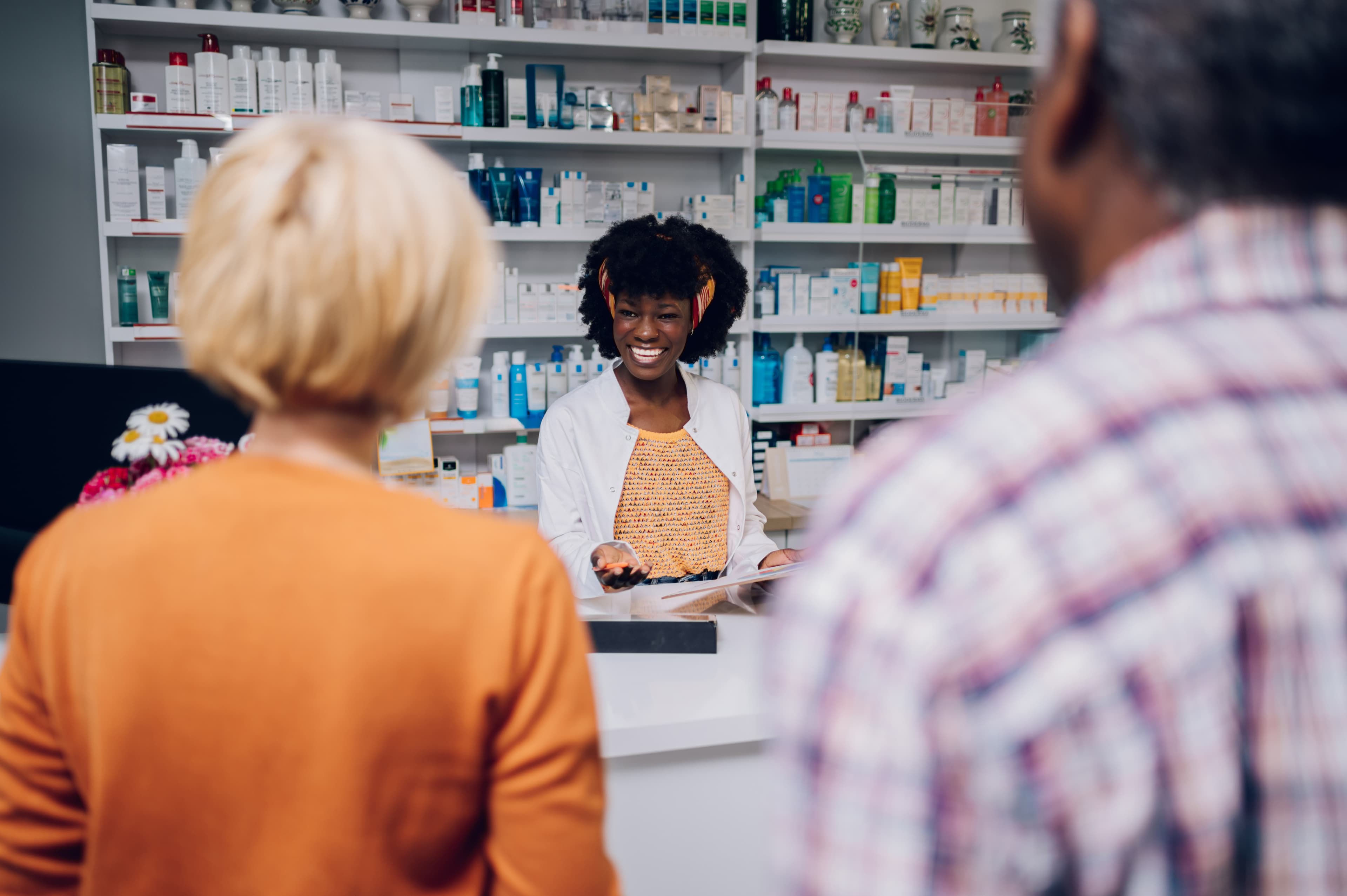 Pharmacist assisting customer in pharmacy store